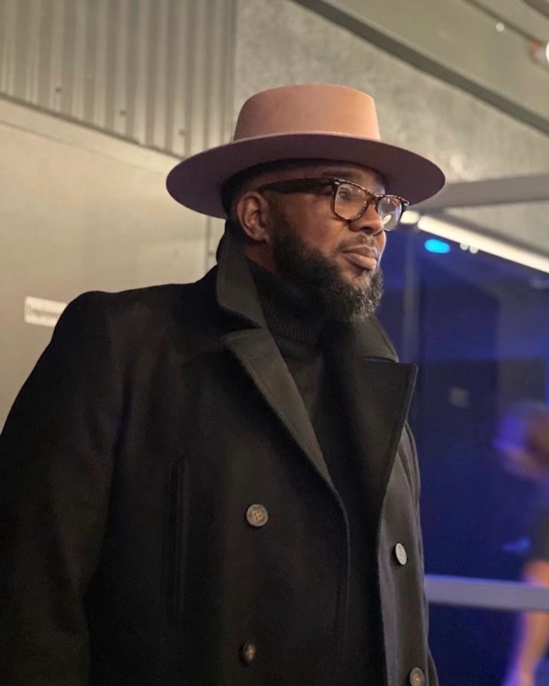 Big Rob, barber at Sapia's Barber Shop in Clearwater, in a pink brimmed hat and black coat
