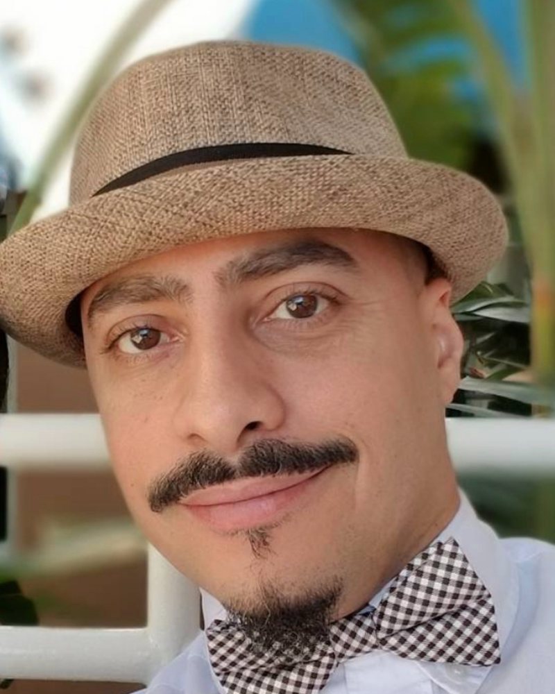 Lil Rob, barber at Sapia's Barber Shop in Clearwater, in a straw hat and bow tie